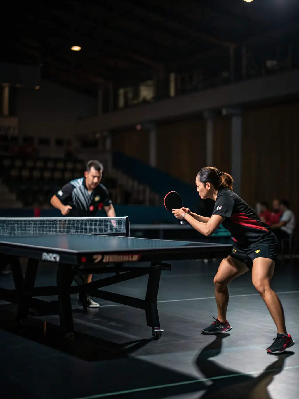 An action shot of a competitive table tennis match at TENNIS DE TABLE AURILLACOIS, featuring two players intensely focused and demonstrating skillful play during a local tournament.